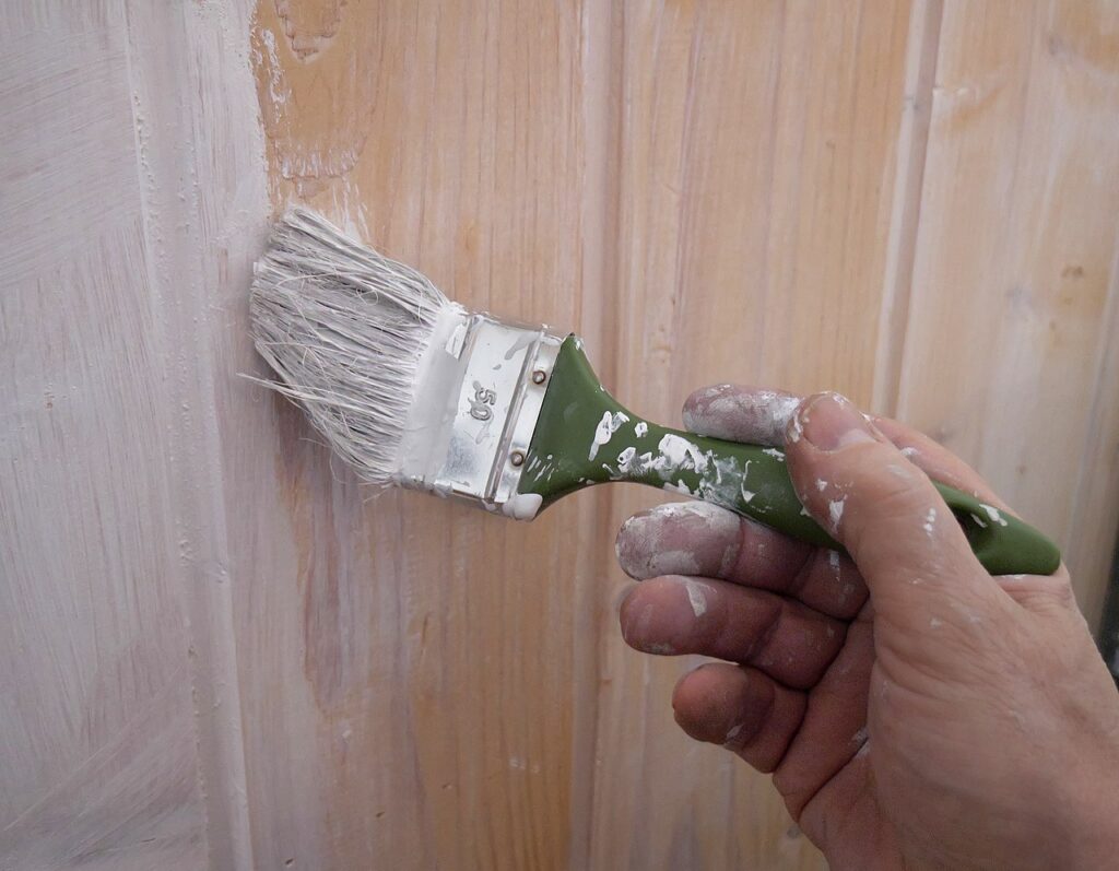 Close-up van hand die een muur schildert met een kwast